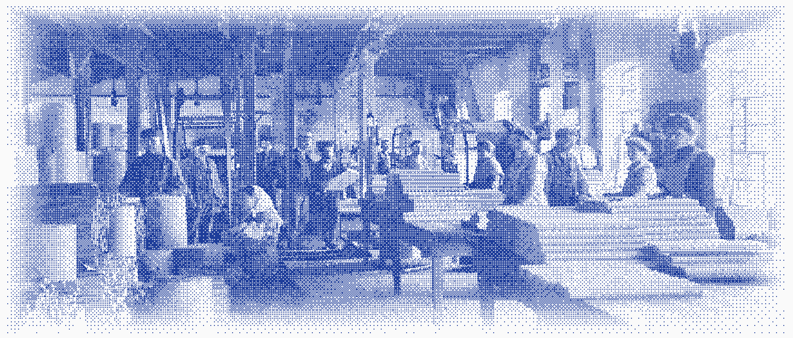 Workers at long tables in a factory hall